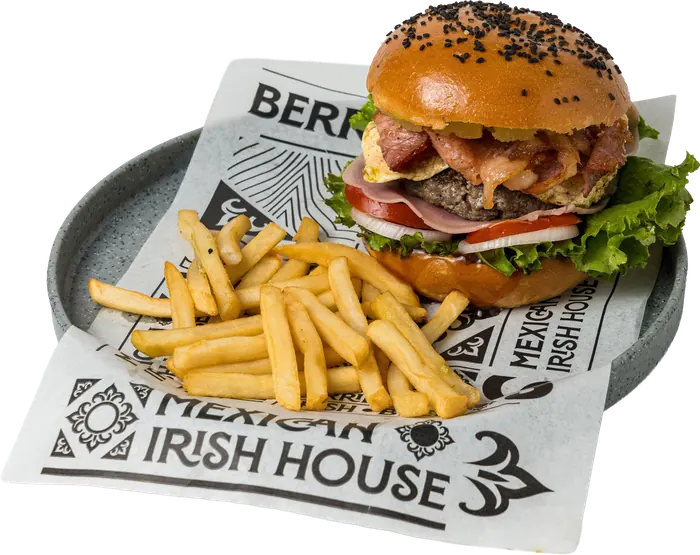 Hamburguesa en pan con ajonjolí negro, con piña, tocino, jitomate y lechuga, con papas a la francesa.