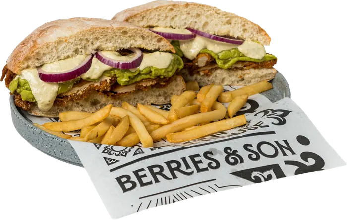 Sándwich en pan de chapata con pollo, guacamole, aderezo y cebolla morada, partido a la mitad, con papas a la francesa.