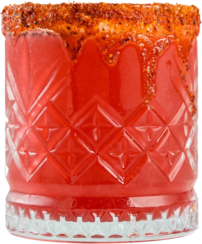 Coctel rojo con escarchado de chile y chamoy en vaso labrado.