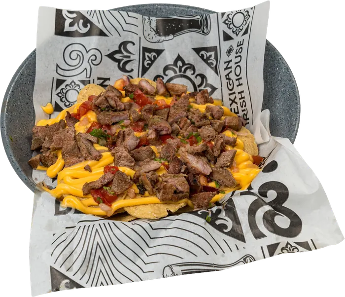 Totopos con arrachera picada, queso amarillo y salsa, en tazón.